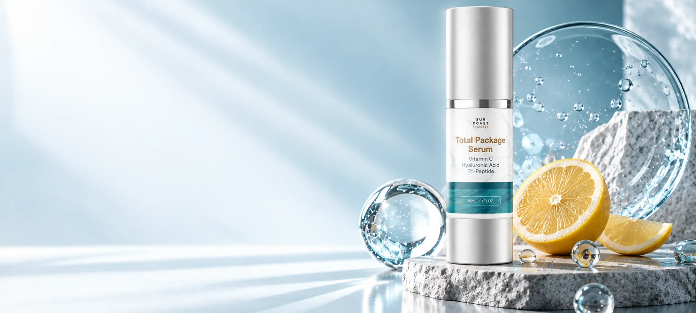 The Total Package Serum beside a sliced lemon and splashing water